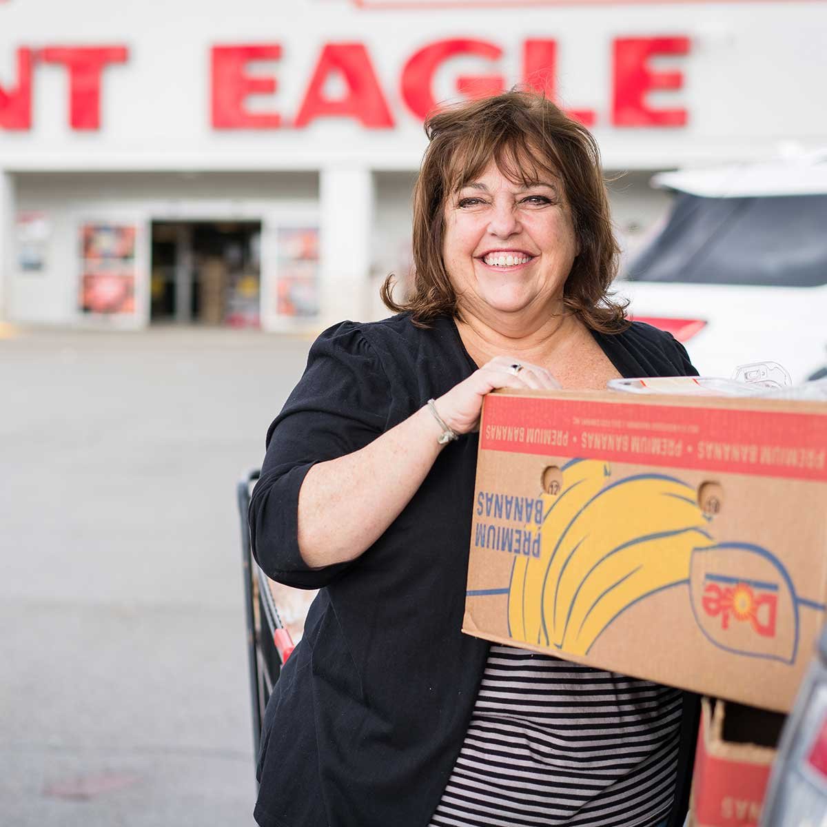 Lady picking up bananas at Giant Eagle