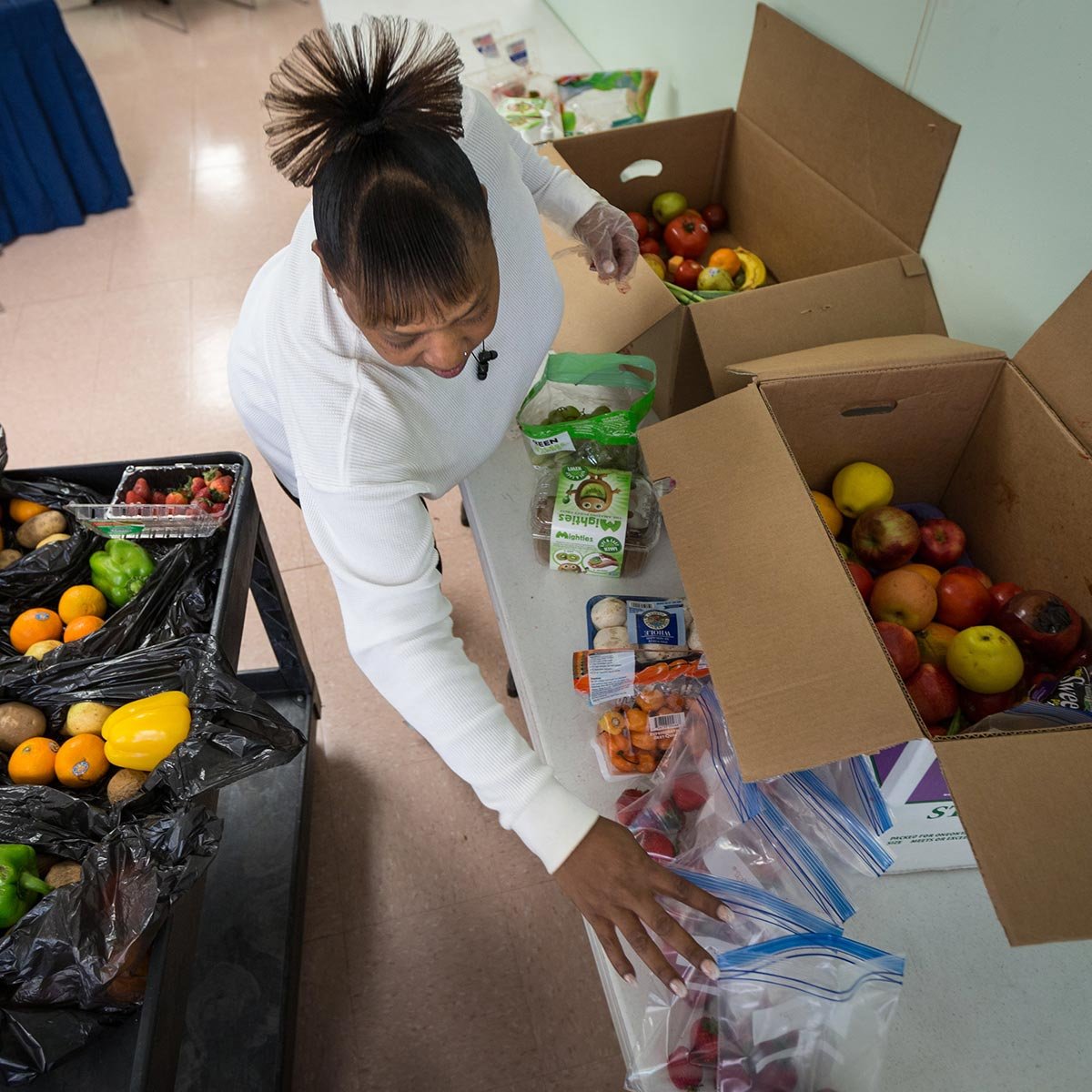 Woman unpacking rescued fruit and vegetables from boxes